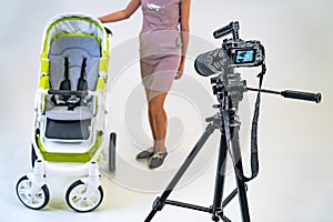 Camera standing in the photo studio. Making video in light studio for baby carriage. photo