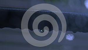 Camera static through a window on raindrop sticks on a Clothes rack and blur background