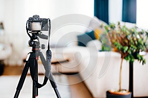 Camera on tripod taking photographs of interior design, furniture and houses