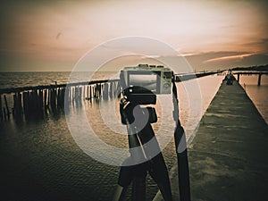Camera on a tripod  . taking pictures of the beautiful moments during the sunset ,sunrise.Silhouette of camera on tripod on
