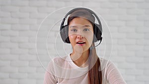 Camera view of Happy young asian business woman wears headset talk to online video conference call with her business team during q
