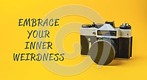 A camera with the words embrace your inner weirdness written below it