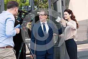 cameraman and anchorwoman with aggressive businessman