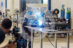 Cameraman with digital film camera in industrial steelworks