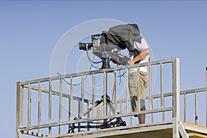 A cameraman filming a football game on a stadium