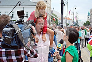 The cameraman filming outdoor event. TVN reporter