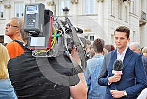 The cameraman filming outdoor event. TVP reporter