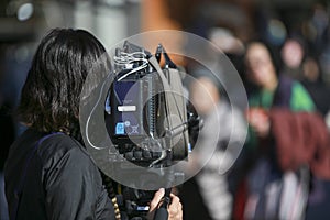 Cameraman with professional recording equipment doing live interview or reporting