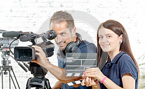 A cameraman and a young woman with a movie camera and clapper