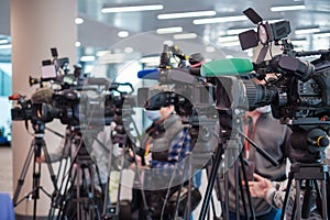 Cameramen shooting interview in modern hall