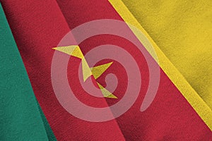 Cameroon flag with big folds waving close up under the studio light indoors. The official symbols and colors in banner