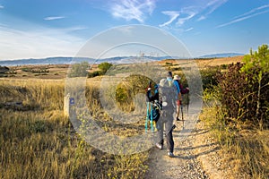 Camino de Santiago, Spain - Pilgrims Hiking through Countryside Past a Waymark Post along the Way of St James Camino de Santiago photo