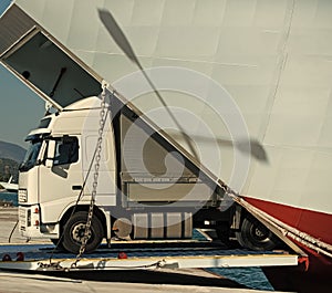 Camion rides out of ferry, ferryboat on sunny day. Intercontinental transport. argo van, truck, kamion transports goods photo