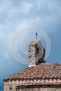 Sardinia. San Giovanni Suergiu. Palmas. Ancient Church of Santa Maria di Palmas, 11th century AD. Roof with red tiles and belfry photo