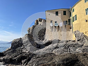 Camogli. Fisherman town by sea. Italy, Ligurian coast. Stone tower, castle on rock. Sunny day.
