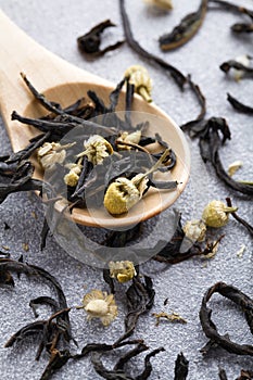 Camomile herbal tea with wood spoon on blue background