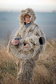 Wildlife photographer in the ghillie suit working