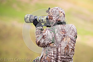 Camouflaged photographer using camera photo