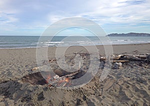 Camp fire Burning at the beach, fire Wood, no People at the ocean