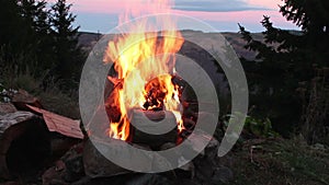 Camp fire with mountain landscape in background