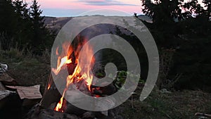 Camp fire with mountain landscape in background