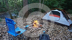 Camp kettle in the Blue Ridge Mountains in Asheville, North Carolina. Outdoor lifestyle with axe, cast iron skillet, flannel blan