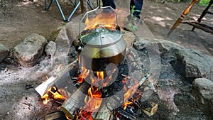 Camp kettle in the Blue Ridge Mountains in Asheville, North Carolina. Outdoor lifestyle with axe, cast iron skillet, flannel blan