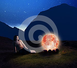 Camp moon. Woman contemplating next to the moon