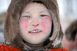 Camp of nomadic Nenets, far north, Yamal Peninsula, pastures of the Nenets, a girl playing on deer pastures stroking her deer