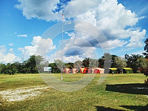 A camp scout adventour tent in a field with a bright sky and cloud