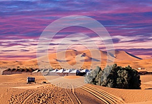 Camp site with tents over sand dunes in Sahara Desert photo