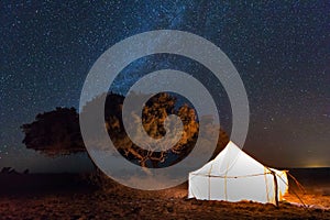 Camp with tent in the desert among sandy dunes. Night with stars in the Sahara, Morocco