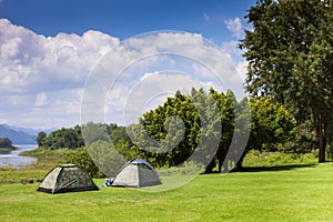 Camp and tent on green grass field under clear sky