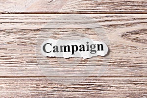 Campaign of the word on paper. concept. Words of Campaign on a wooden background