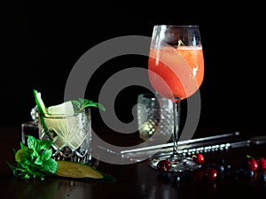 Campari cocktail and cucumber gin at the bar tab with dark background
