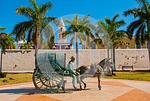 CAMPECHE, MEXICO: Statue of a horse drawn carriage in San Francisco de Campeche. A man sitting in a wagon with a barrel. next to t