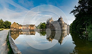 View of the historic Chateau Trecesson castle in the Broceliande Forest with reflections in the pond