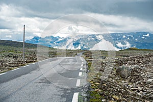 Camper car in norwegian mountains. Tourism vacation and travel. Caravan car RV travels on the mountain road, pass Norway