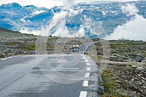 Camper car in norwegian mountains. Tourism vacation and travel. Caravan car RV travels on the mountain road, pass Norway