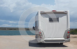 camper car on the sandy shore near the river on a summer day