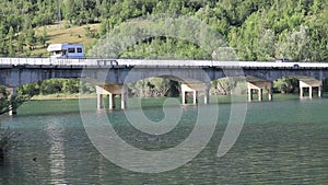Camper crosses the bridge over the lake of Barrea, Italy