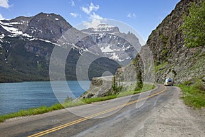 Camper travels alongside St Mary Lake and mountains in Glacier National Park