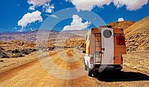 Camper truck trip on red dirt track sand road, barren lonely wild desert valley - Chile, Atacama region, Pan de Azucar NP