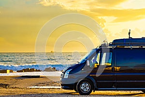 Camper van on beach at sunrise photo