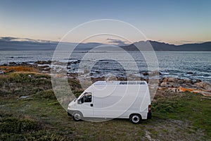 Camper van motorhome with solar panels drone aerial view on a sea landscape with mountains living van life in Galiza, Spain photo