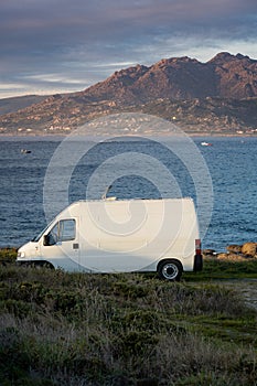 Camper van motorhome with solar panels view on a sea landscape with mountains living van life in Galiza, Spain photo