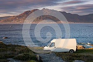 Camper van motorhome with solar panels view on a sea landscape with mountains living van life in Galiza, Spain photo