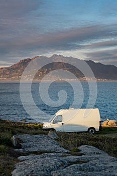 Camper van motorhome with solar panels view on a sea landscape with mountains living van life in Galiza, Spain photo