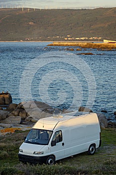 Camper van motorhome with solar panels view on a sea landscape with mountains living van life in Galiza, Spain photo