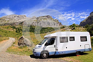 Camper van in mountains blue sky